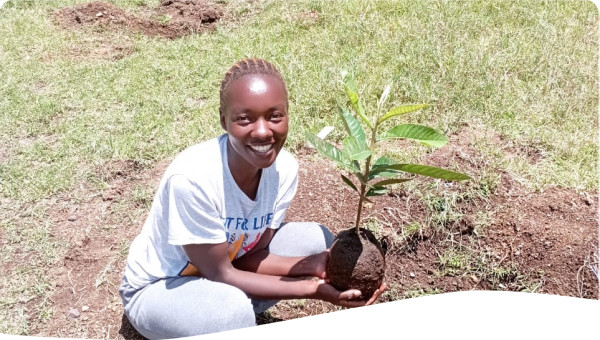 An image of Bikoro with a loquat tree seedling in hand ready for planting